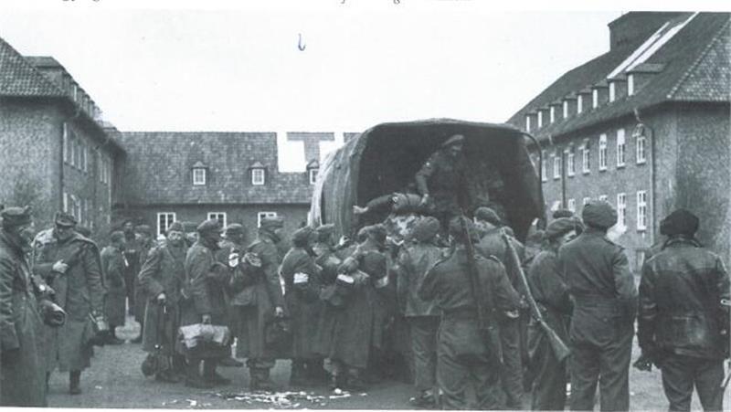 Bewacht von britischen Soldaten werden die deutschen Soldaten in der Estetal-Kaserne in Lastwagen eingesammelt und in Gefangenenlager gebracht.