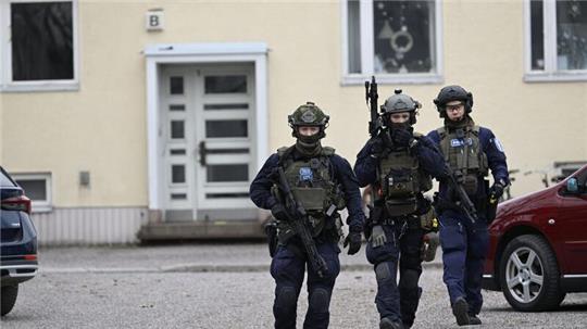 Bewaffnete Polizisten gehen in der Nähe der Viertola-Schule. Bei dem Vorfall an einer Grundschule in der finnischen Stadt Vantaa nördlich von Helsinki sind Kinder verletzt worden. Ein zwölf Jahre altes Kind stirbt.