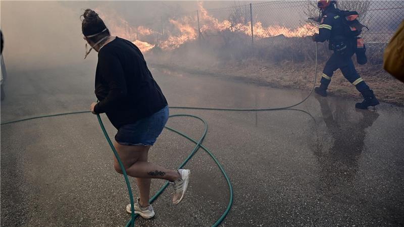 Bewohner und Feuerwehrleute bekämpfen die Flammen.