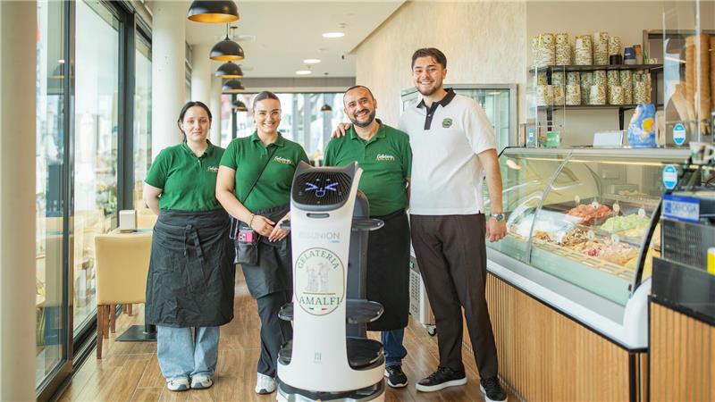 Roboter „Bella“ serviert im Café: Lacher bei der Premiere Beyza Nilic (links), Nisa Biçen, Fikri und Ahsem Shukri – gemeinsam mit Service-Roboterin Ella für besten Eisgenuss in Bremerhaven.