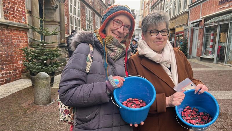 Bianca Bahlke (rechts) und Ilona Draws-Heiner von der Alzheimer-Gesellschaft verkauften vor dem Stader Rathaus die Glücksschweine mit.