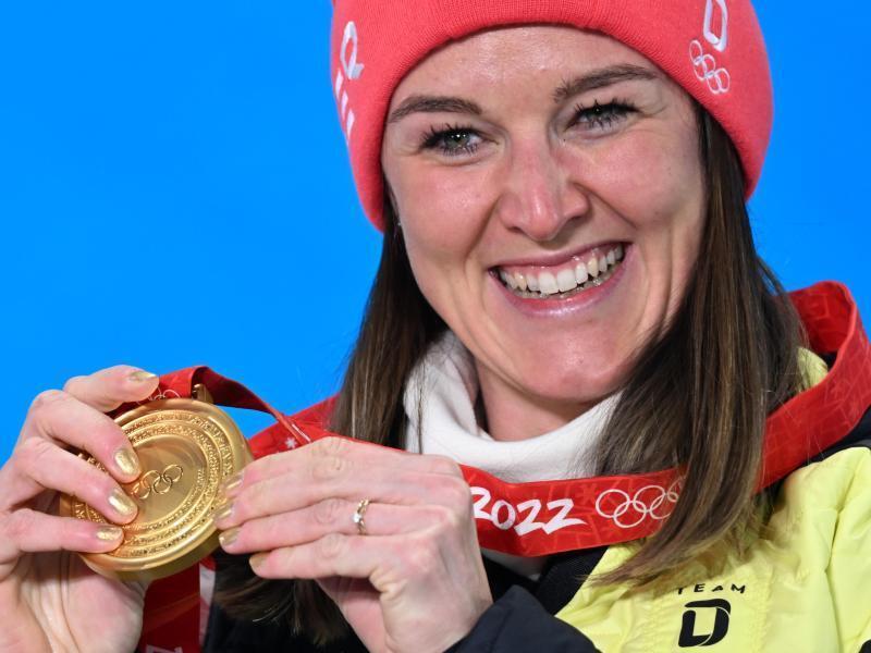 Biathletin Denise Herrmann zeigt stolz ihre Goldmedaille. Foto: Angelika Warmuth/dpa