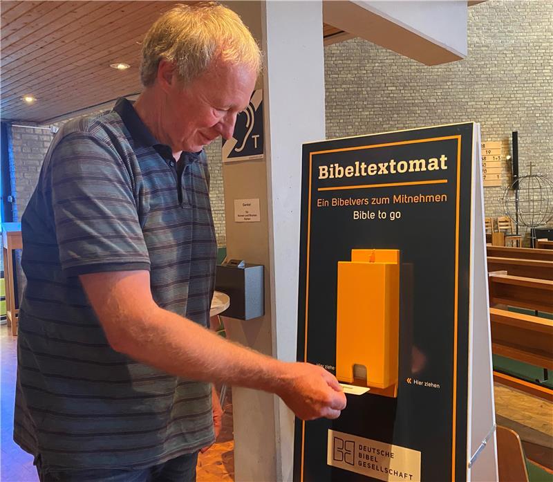 Hartwig Holthusen in der St.-Paulus-Kirche am neuen Aufsteller mit dem von der Deutschen Bibelgesellschaft entwickelten Kartenspender.