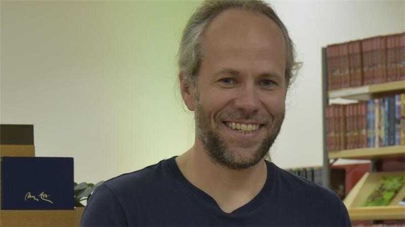 So kann jeder Buxtehudes Bibliothek der Zukunft mitgestalten Porträt von Peter Jobmann mit Bücherregalen im Hintergrund