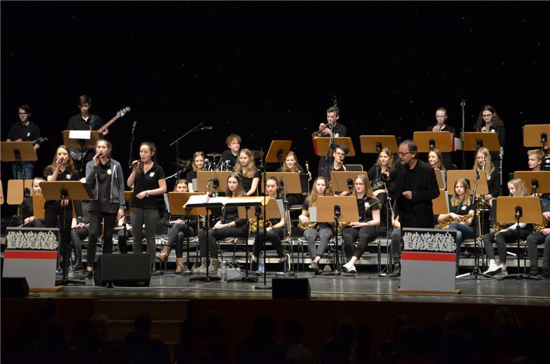 Vincents Bigband erklärt 400 Kindern die Jazzmusik Bigbandleiter Frank Münter (vorne rechts) beweist Entertainer-Qualitäten: Mit der über 30-köpfigen Vincents Bigband animiert er über 400 Grundschüler im Stadeum zum Mitsingen und Schnipsen und erklärt dabei die Struktur eines Jazzliedes. Das Konzert fand zum dritten Mal statt – die Kreisjugendmusikschule ließ nach dem Auftritt Instrumente ausprobieren. Fotos: Husung