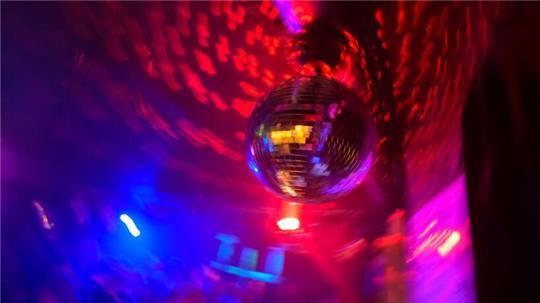 Eine Discokugel hängt in einer Diskothek.