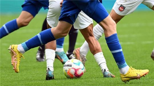Fußballspieler kämpfen um den Ball (Symbolbild).