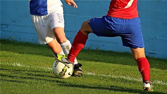 Zwei Fußballerinnen kämpfen um den Ball.