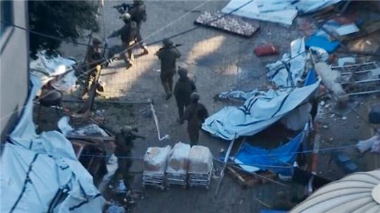 Bild aus einem von den israelischen Verteidigungskräften veröffentlichten Video gehen israelische Soldaten in der Nähe des Schifa-Krankenhauses in Gaza-Stadt.