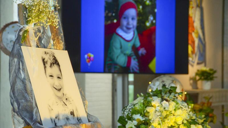 Trauernde nehmen still Abschied vom verstorbenen Arian Bilder von Arian aus glücklichen Tagen sollen die Trauernden an den verstorbenen Elmer Jungen erinnern.