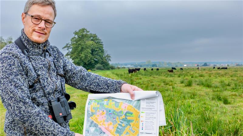 Weg vom Bullenbruch nach Ladekop - Naturschutz macht es möglich Biologe Henning Kunze mit einer Wiesenvogelkarte vom Bullenbruch.