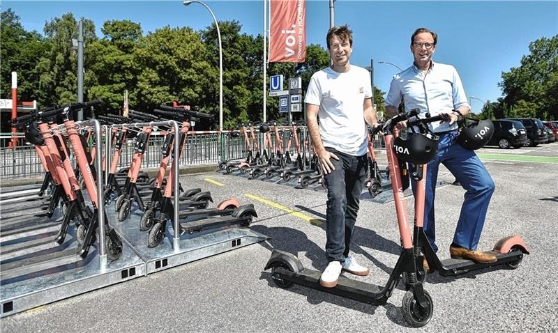 Bis Januar wollen Claus Unterkircher (links), Deutschlandchef des E-Scooter-Herstellers Voi, und Henrik Falk, Vorstandsvorsitzender der Hochbahn, die 60 Roller testweise verleihen. Foto: Hochbahn
