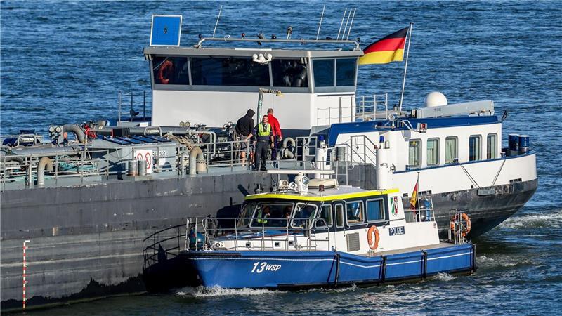 Bitte mal Führerschein und Fahrzeugschein zeigen. Ein Polizeiboot der Wasserschutzpolizei Duisburg liegt bei der Kontrolle von Binnenschiffen seitlich an einem Tankschiff auf dem Rhein. 