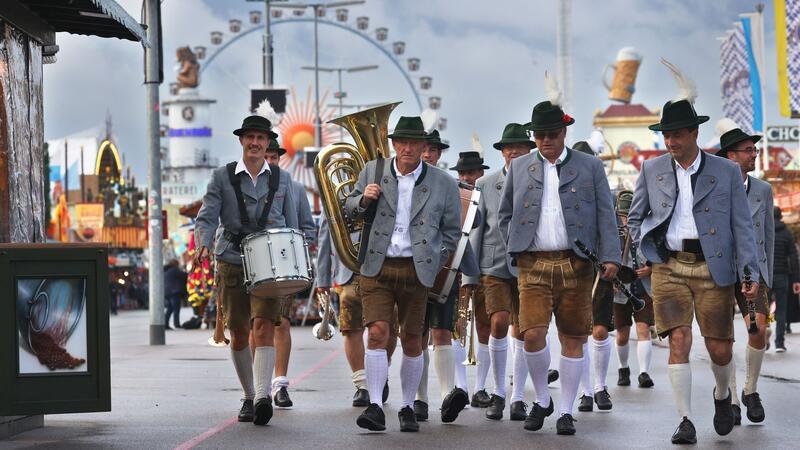 Wiesnmaß knackt die 15-Euro-Marke Blasmusiker gehen vor dem Riesenrad über den Festplatz. (Archivbild)