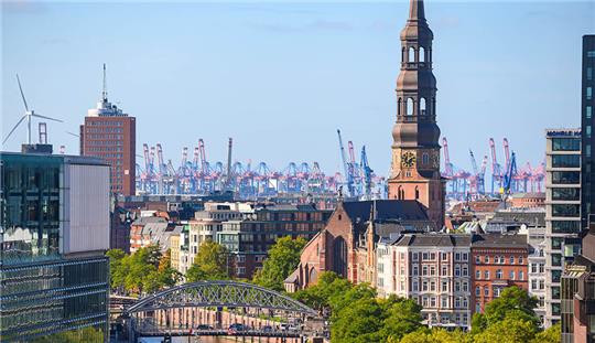 Blauer Himmel über Hafenkränen, Hauptkirche St. Michaelis und weiteren Wohn- und Geschäftsgebäuden in der Altstadt. Unter den fünf deutschsprachigen Millionenstädten haben die Erwachsenen in Deutschland eine eindeutige Lieblingsmetropole - Hamburg. Foto: Jonas Walzberg/dpa