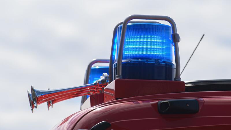Blaulichter leuchten auf dem Dach eines Einsatzfahrzeugs der Feuerwehr.