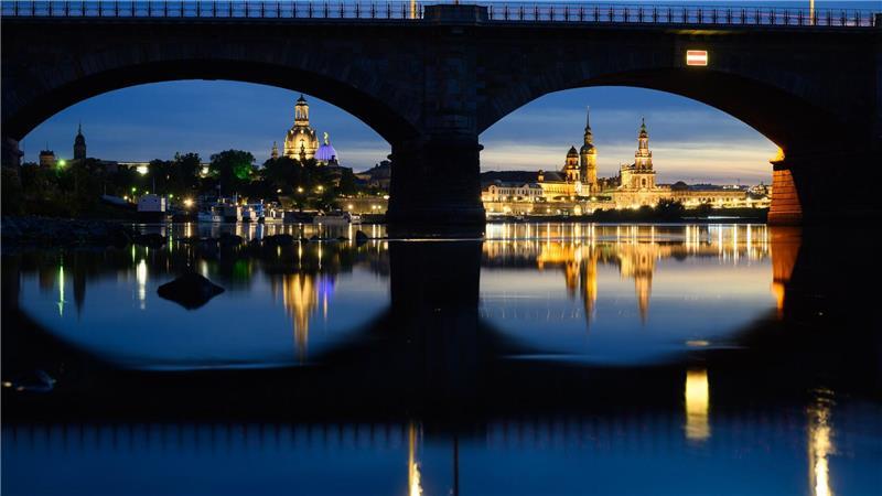 Bilder des Tages Blick am Abend in Dresden durch die Brückenbögen der Albertbrücke auf die historische Altstadtkulisse an der Elbe mit der Frauenkirche (l-r), der Kuppel der Kunstakedmie mit dem Engel „Fama“, dem Terrassenufer, dem Ständehaus, dem Hausmannsturm, der Hofkirche und der Semperoper.