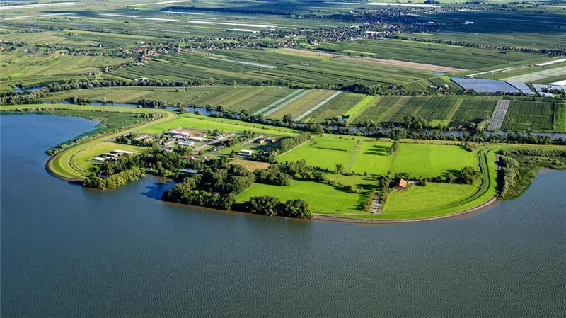 Hahnöfersand: Gefängnis-Abriss verzögert sich - mit Folgen für Jork Blick auf Hahnöfersand: Links sind das Gefängnis und der Hafen zu sehen, rechts der Schafstall des Deichverbandes. Oberhalb der Borsteler Binnenelbe sind die Schallen und die K39 zu sehen.