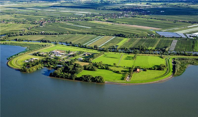 Blick auf Hahnöfersand: Links sind das Gefängnis und der Hafen zu sehen, rechts der Schafstall des Deichverbandes. Oberhalb der Borsteler Binnenelbe sind die Schallen und die K39 zu sehen.