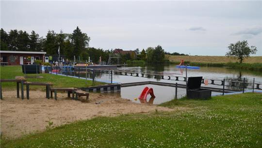 Blick auf das Naturbad mit Matschecke und Planschbereich.