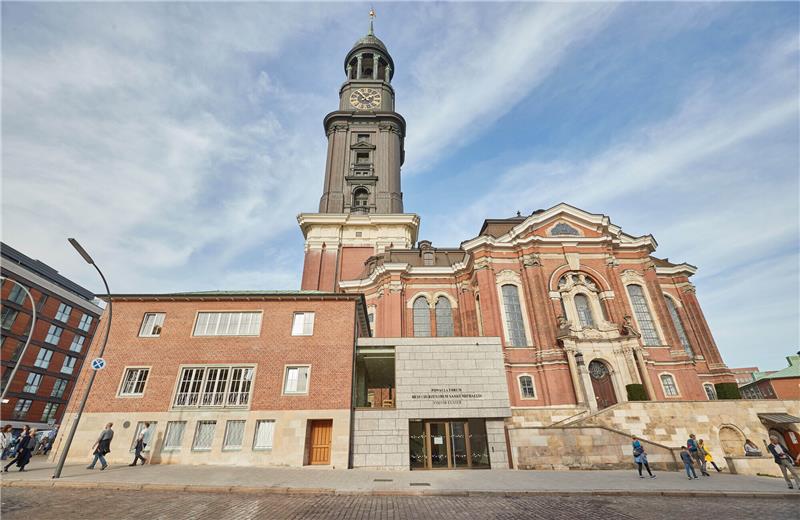 Blick auf das neue Besucherzentrum an der Kirche Sankt Michaelis (Powalla Forum). Dahinter ist der Kirchturm (Michel) zu sehen. Foto: Georg Wendt/dpa