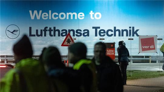 Blick auf den Eingangsbereich zur Lufthansa Technik in Hamburg, vor dem sich auch Streikende versammelt haben. Beim Lufthansa-Bodenpersonal kommt es zu einem dreitägigen Warnstreik.
