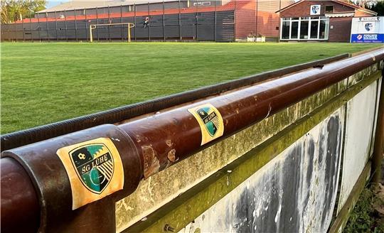 Blick auf den Sportplatz Striep in Steinkirchen: Hinter dem Tor ist die Sporthalle zu sehen, rechts das Vereinsheim und die Würstchenbude der SG Lühe.