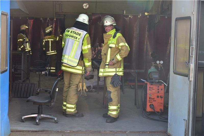Blick auf die Einsatzstelle: Feuerwehrleute nehmen die stark verqualmte Werkstatt in Augenschein. Foto: Beneke