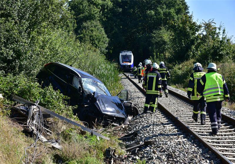 Blick auf die Einsatzstelle in Aspe: Das Auto bleibt an der Böschung liegen, der Zug fährt noch ein ganzes Stück weiter. Feuerwehrleute retten die Passagiere. Foto: Beneke