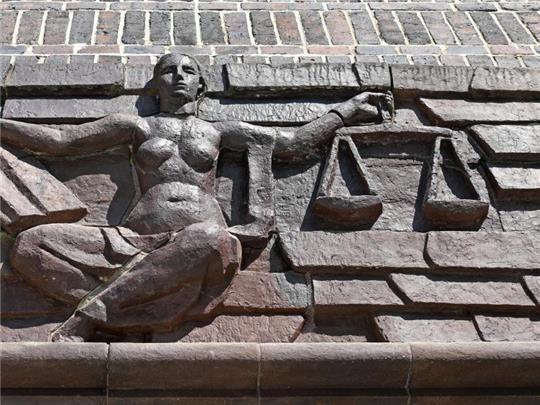 Blick auf die Justitia über dem Eingang eines Landgerichts. Foto: Hendrik Schmidt/dpa-Zentralbild/dpa/Symbolbild