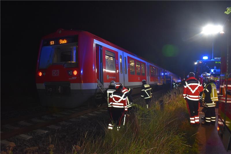 Nach Familienstreit: Pkw von S-Bahn bei Dollern erfasst Blick auf die S-Bahn: Feuerwehrleute und Notfallsanitäter steigen in die S-Bahn, um mit den Fahrgästen zu sprechen und zu überprüfen, ob jemand verletzt worden ist. Foto: Vasel