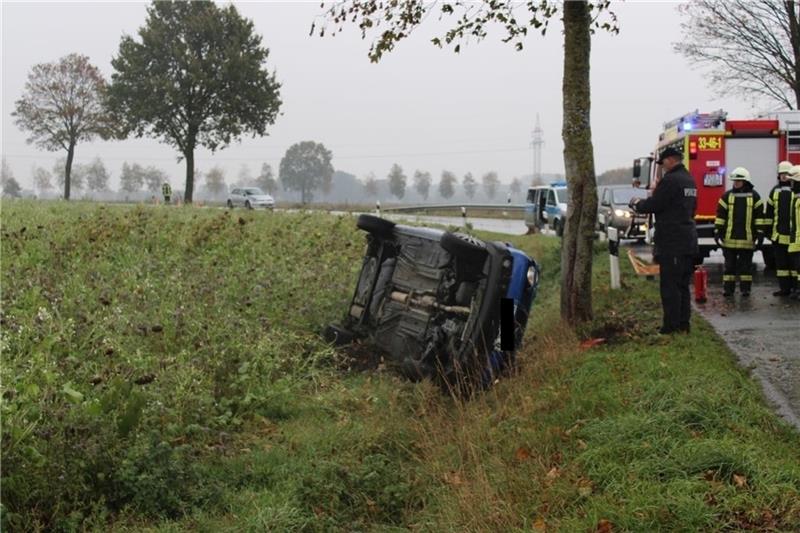 Blick auf die Unfallstelle : Der VW Lupo bleibt auf der Fahrerseite liegen. Die Feuerwehr und Polizei sichern die Straße ab. Foto: Bockelmann