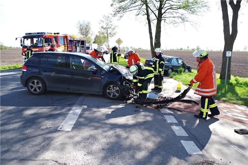 Blick auf die Unfallstelle an der Kreisstraße 3 : Feuerwehrleute nehmen auslaufende Betriebsstoffe am verunfallten VW Golf auf. Foto Hillyer-Funke