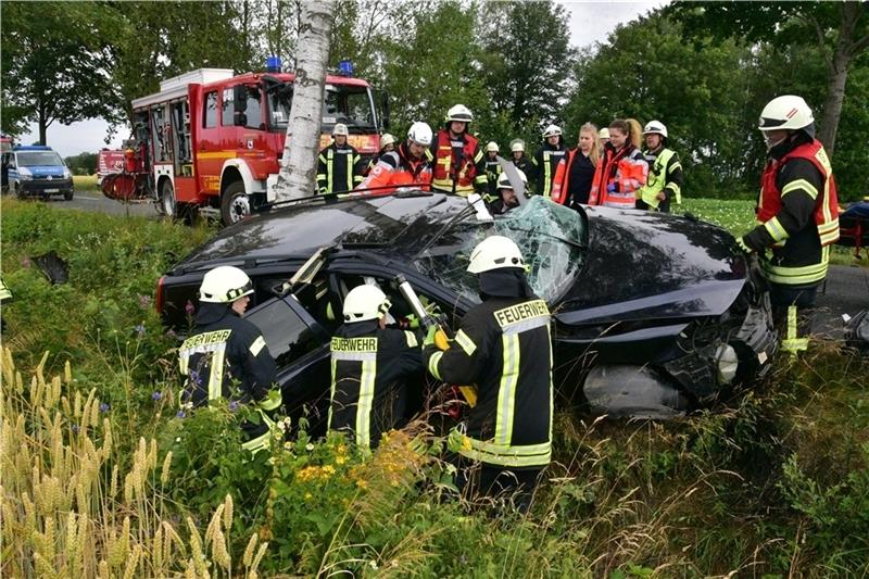 Blick auf die Unfallstelle an der Kreisstraße 49: Feuerwehrleute und Notfallsanitäter versorgen den schwer verletzten Autofahrer. Fotos: Beneke