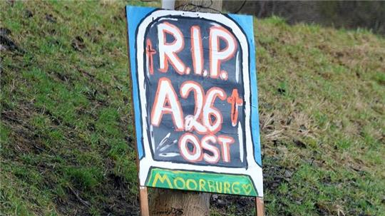Blick auf ein Protestplakat mit der Aufschrift „R.I.P. A26 Ost. Moorburg“ hängt an einem Baum im Stadtteil Moorburg.