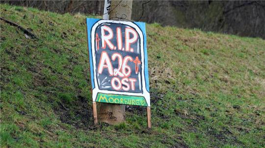 Blick auf ein Protestplakat mit der Aufschrift "R.I.P. A26 Ost. Moorburg" hängt an einem Baum im Stadtteil Moorburg. 