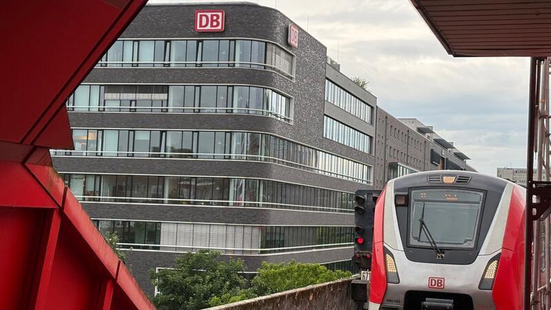 Blick aus dem S-Bahnhof Hammerbrook auf die DB-Zentrale. Ein S-Bahnzug in Richtung Stade fährt gerade ein.