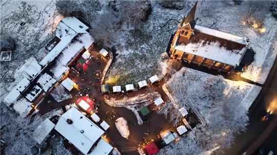Blick aus der Luft auf den Weihnachtsmarkt in Ahlerstedt: Zwischen Gemeindehaus und Kirche sind am Sonntag wieder viele kleine Buden und Zelte aufgebaut.