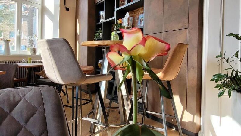 Blick in das – im Inneren – nur 22 Plätze umfassende Café Wasserturm Cuxhaven des Ehepaares Mirabelle und Alain Caboussat aus der Schweiz. Bei schönem Wetter gibt es auch Sitzplätze im Freien.