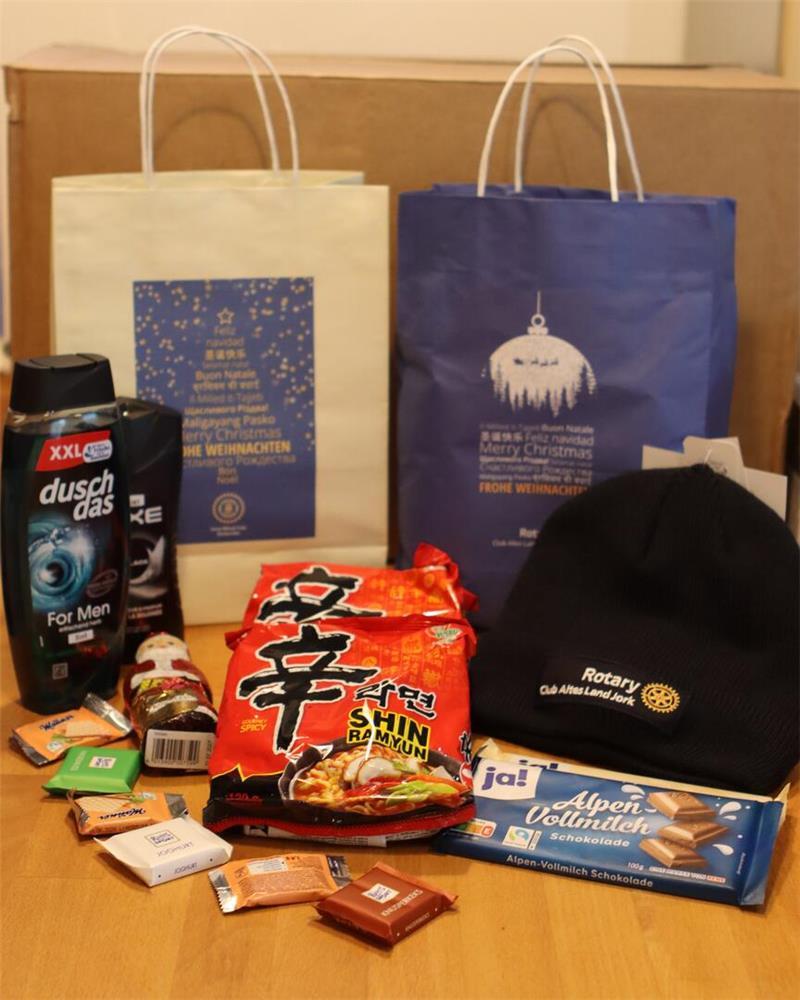 Das Leben der Seeleute: Mit der Seemannsmission an Bord im Stader Hafen Blick in den Inhalt einer Geschenktüte, auf der „Frohe Weihnachten“ in vielen Sprachen steht.