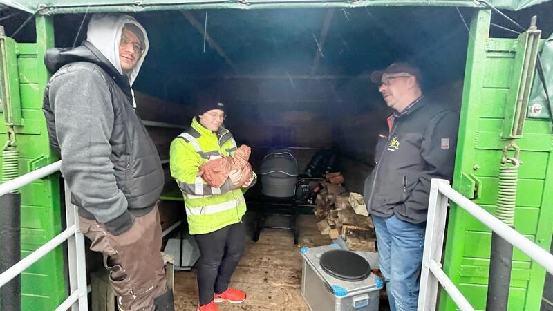 Stader Protest-Camp der Landwirte: Im strömenden Regen an der Feuertonne Der mit Plane überdachte Viehwagen dient als Lager und als trockener Aufenthaltsraum.