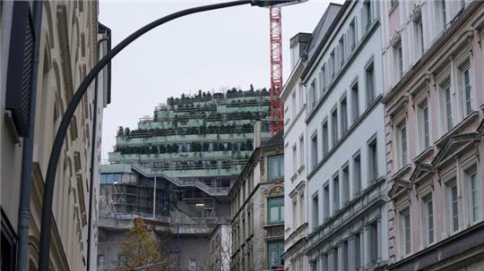 Blick von einer Straße im Karolinenviertel auf den begrünten Hochbunker St. Pauli auf dem Heiligengeistfeld.