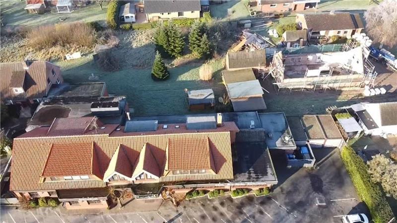 Zwei Linden in Balje: Hotelkomplex wird deutlich erweitert Blick von oben auf das ganze Areal: Vorne das Hotel Zwei Linden mit Anbauten, rechts die entkernte Bäckerei und dahinter das Altenteilerhaus, in dem zwei Ferienwohnungen entstehen. Links mittig die Grünfläche.