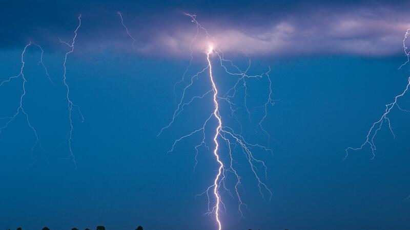 Versicherer: Weniger Schäden durch Wetterextreme in Hamburg Blitze eines Gewitters leuchten am Abendhimmel.
