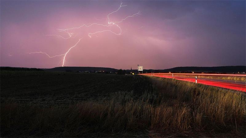 Blitze zucken bei einem abendlichen Gewitter über Mittelfranken.