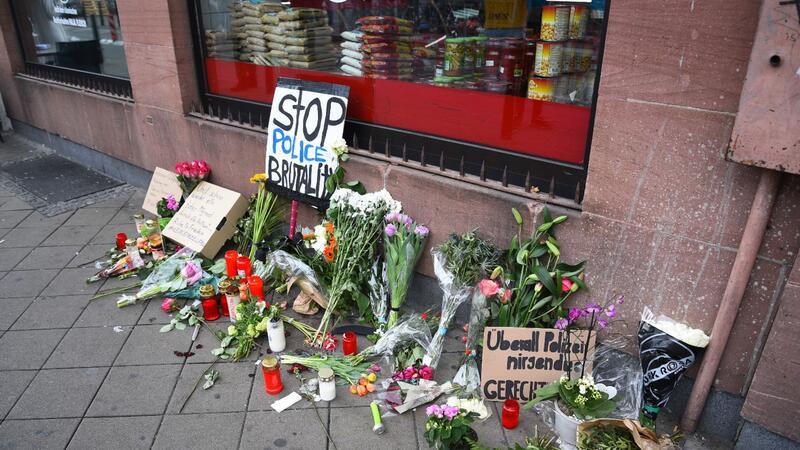 Prozess nach Polizeikontrolle - Beamte auf der Anklagebank Blumen, Kerzen und Schilder liegen in Mannheim an dem Ort, an dem ein Mann Anfang Mai 2022 nach einer Polizeikontrolle starb.