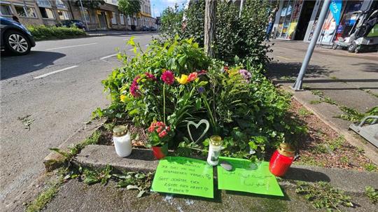 Blumen und Grablichter sind an der Unfallstelle aufgestellt worden.