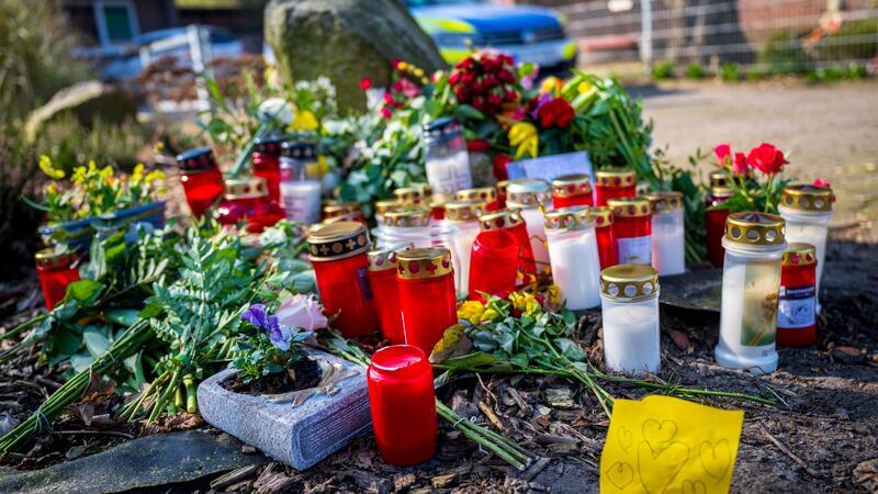 Blumen und Kerzen liegen vor einem Einfamilienhaus.