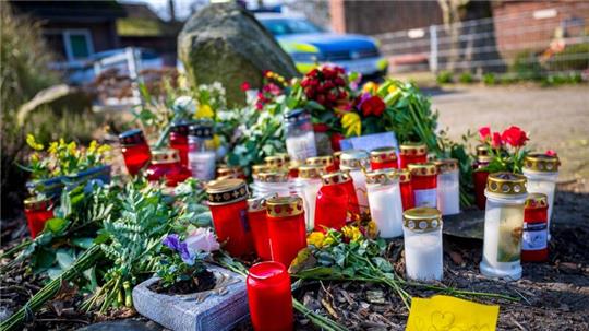 Blumen und Kerzen liegen vor einem Einfamilienhaus in Scheeßel.