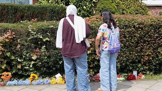 Blumen und Kerzen stehen und liegen am Tatort.